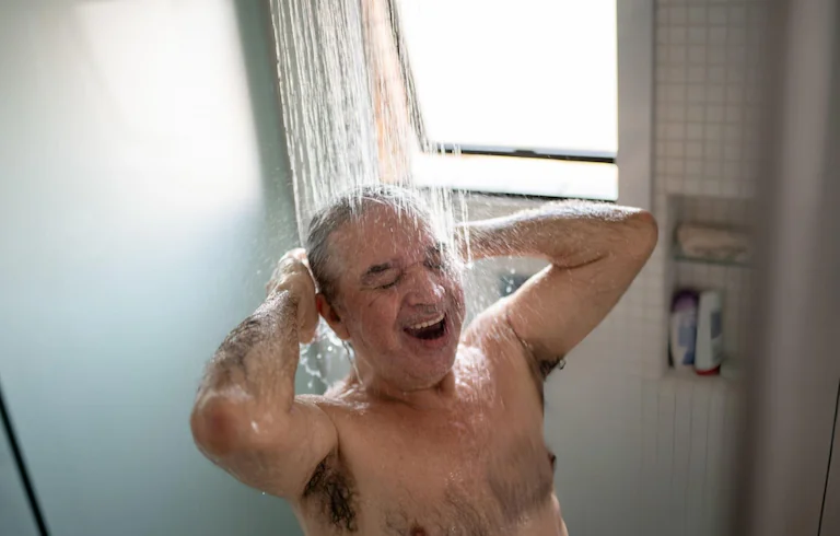 Homem desfrutando de um banho relaxante com alta pressão no chuveiro